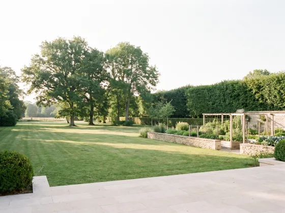 Jardin clos vu depuis une terrasse, arbres matures en fond