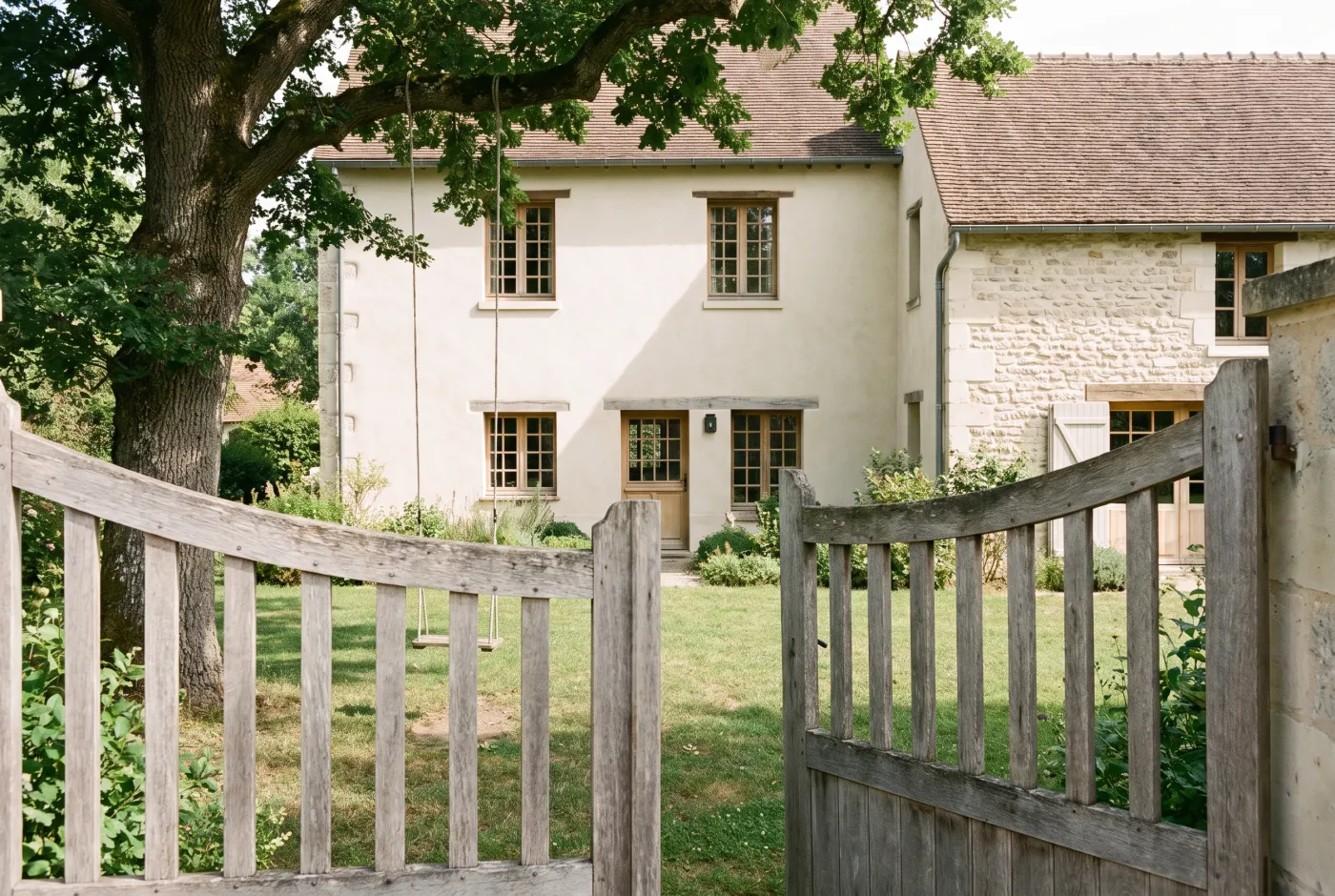 Maison familiale des Yvelines vue depuis le portail, jardin en premier plan
